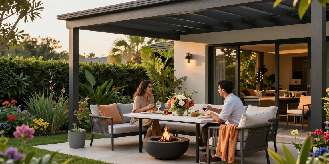 Elegante Terrassenüberdachung freistehend über gemütlicher Gartenterrasse mit Blumen und Grill.